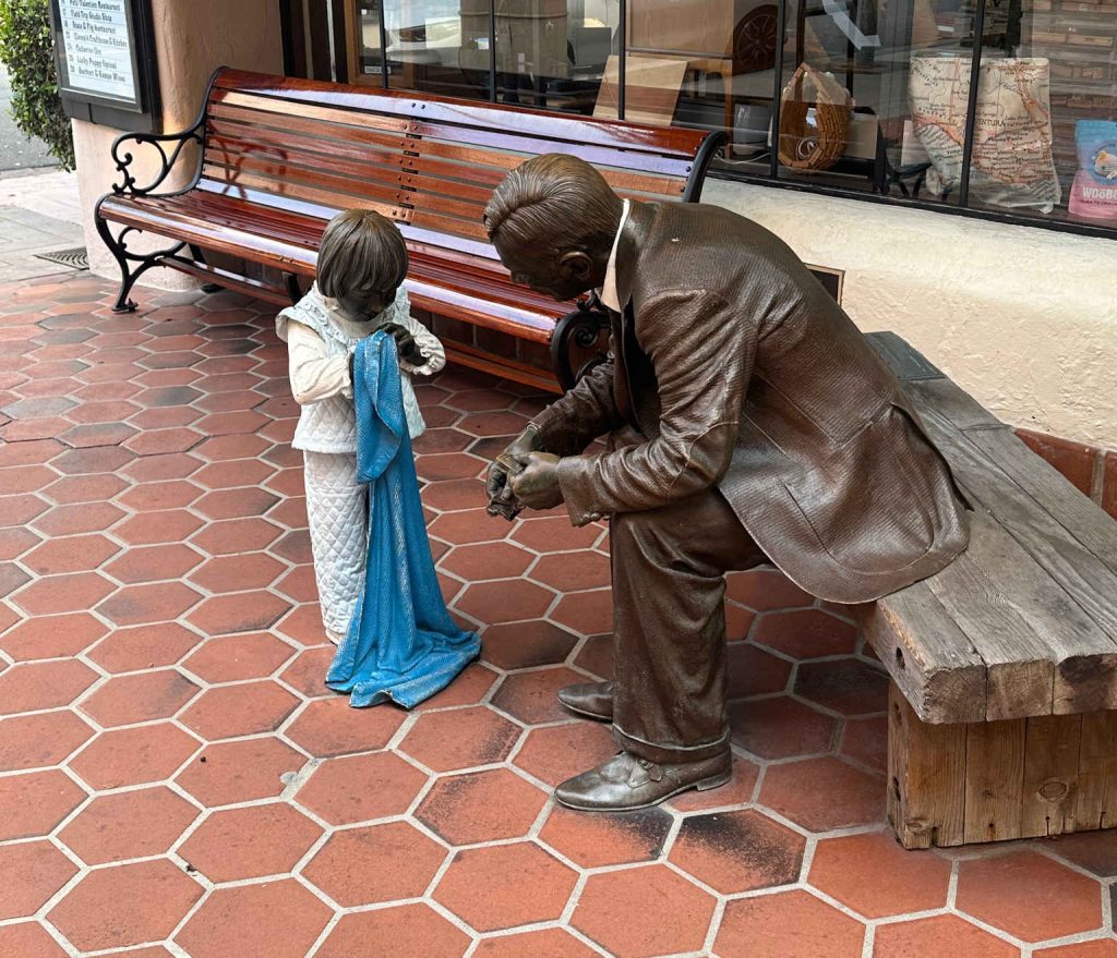 Bronze statue of man talking to girl