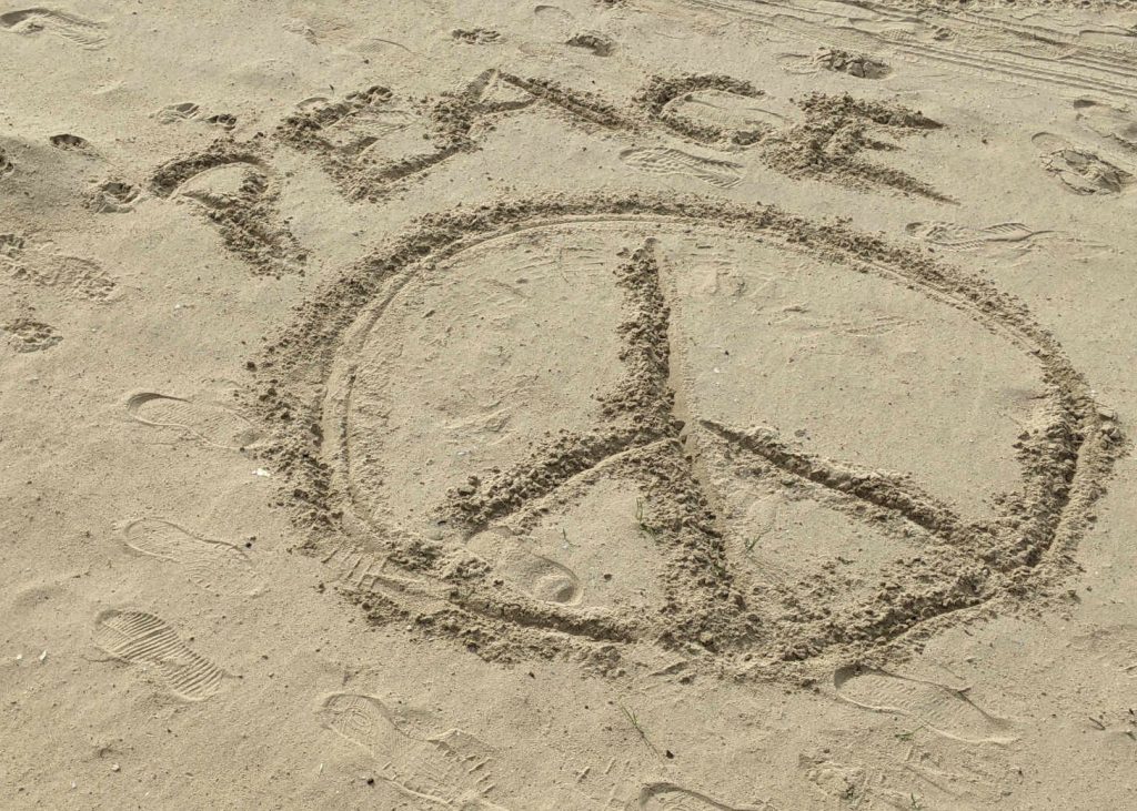 Peace sign in sand